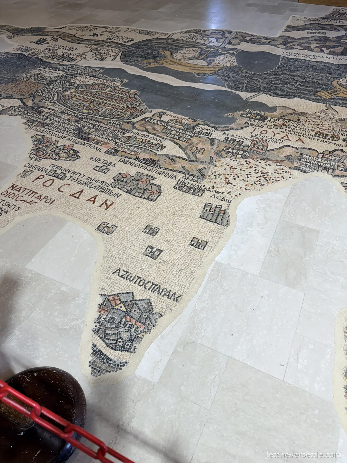 A close view of the Madaba mosaic map floor showing the coastline, walled towns and Greek place names picked out in tiny stone tiles