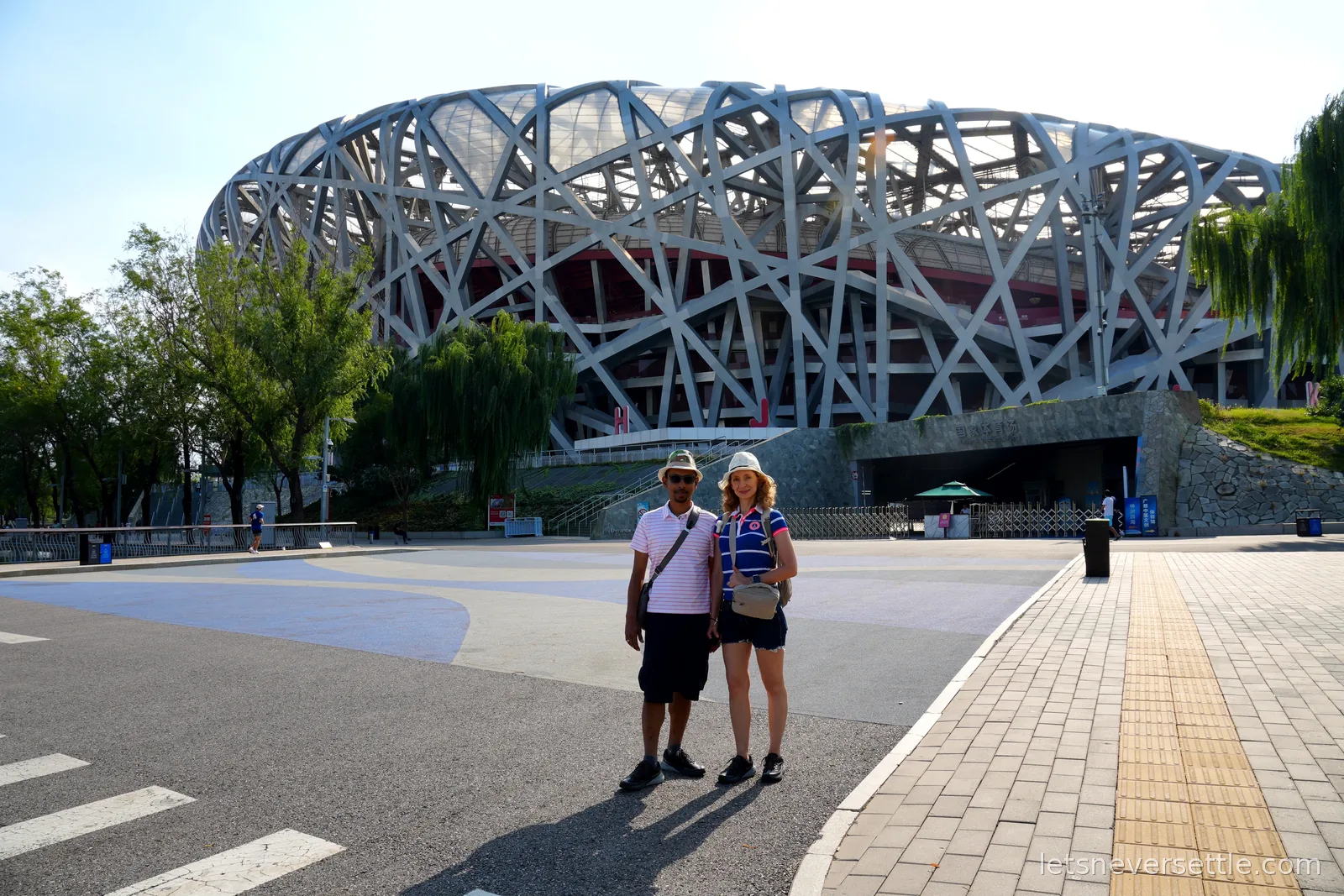 Inga and Dileep standing in front of the steel lattice of the Bird's Nest, Beijing's National Stadium