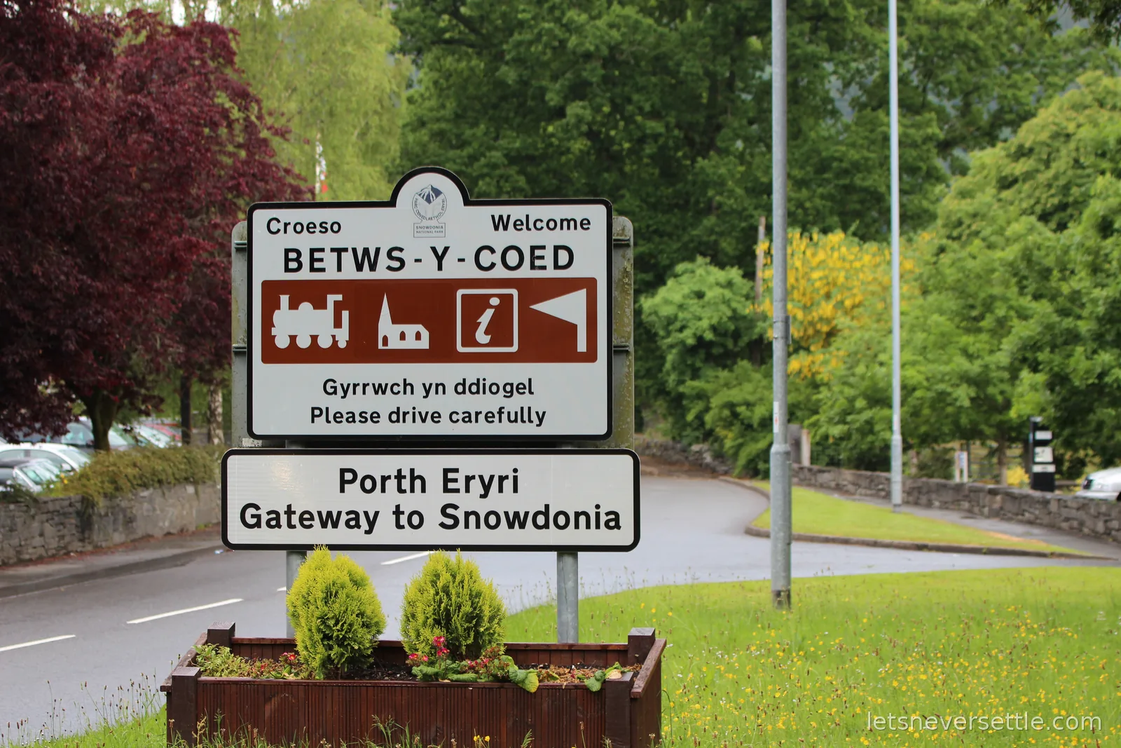 Brown and white roadside sign reading Croeso Welcome Betws-y-Coed, with a second sign below reading Porth Eryri Gateway to Snowdonia