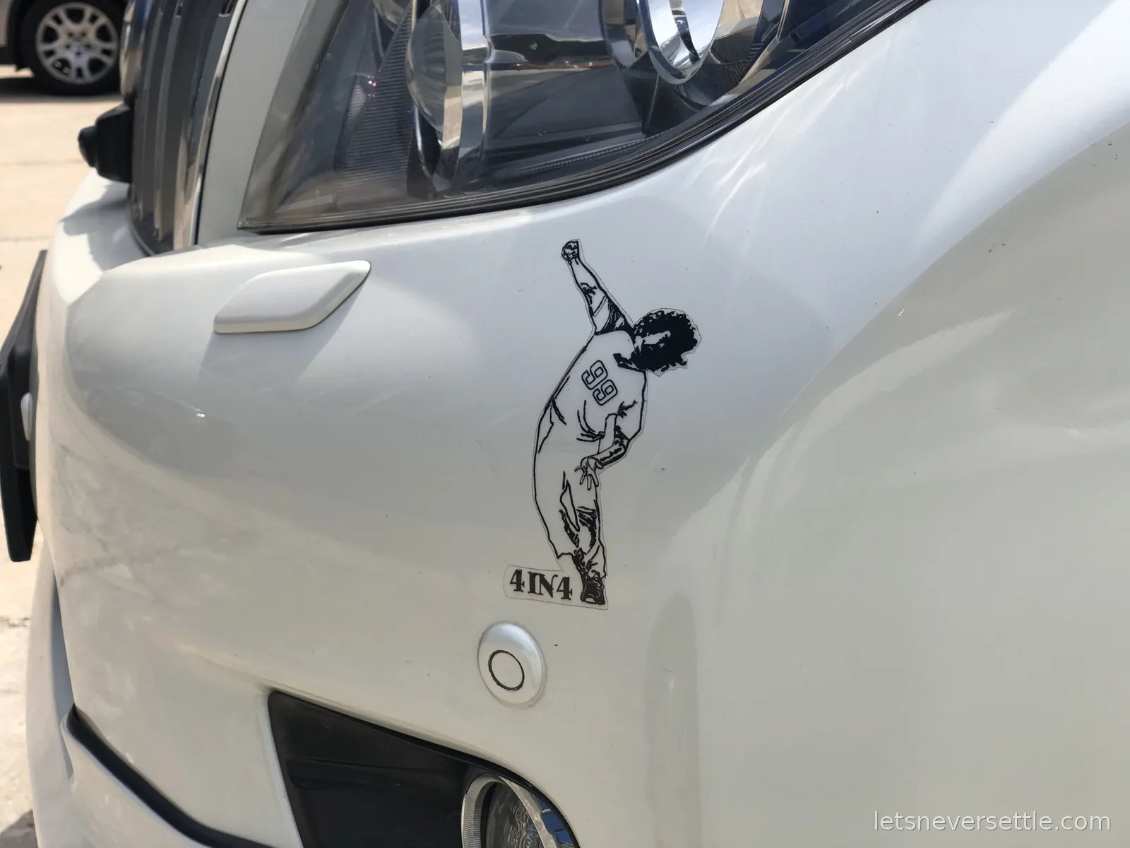 A sticker on a white SUV bumper showing bowler Lasith Malinga mid-celebration with the caption 4IN4