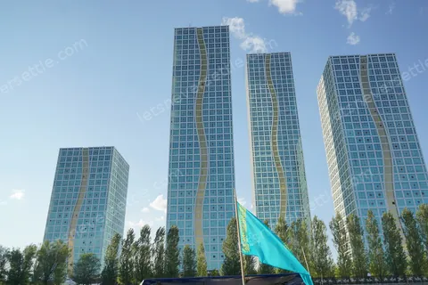 Three glass towers in Astana with the Kazakh flag flying below them