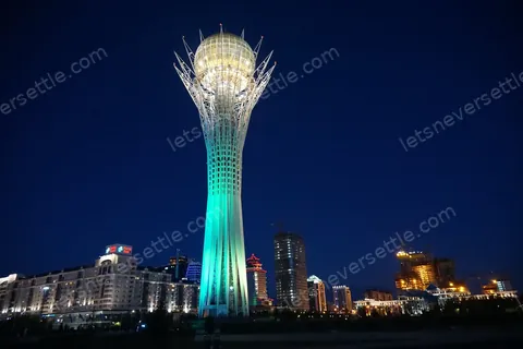 The Bayterek tower in Astana lit up at night above the city
