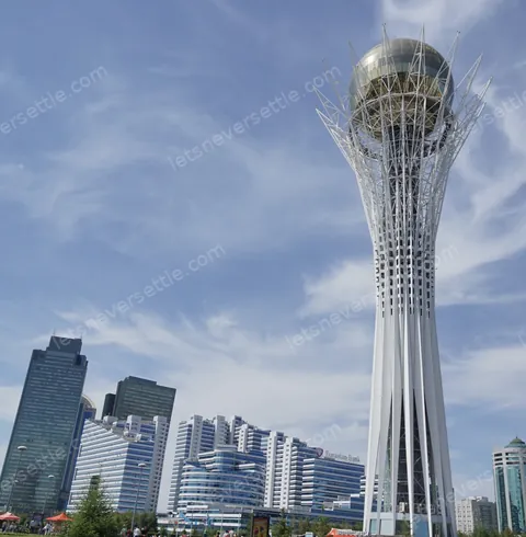 The Bayterek tower and its golden sphere against a blue sky, ringed by Astana towers
