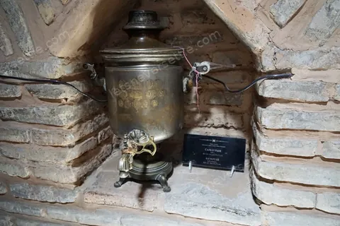 An old brass samovar fixed to a log wall