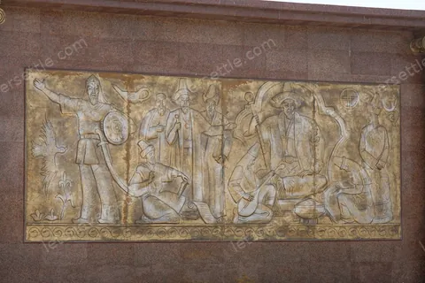A carved stone relief of working figures set into a wall