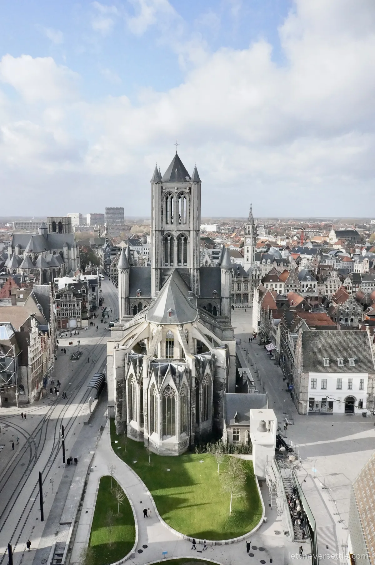 View from the Ghent belfry over the rear of St Nicholas' Church, with the old post office clock tower and city rooftops beyond