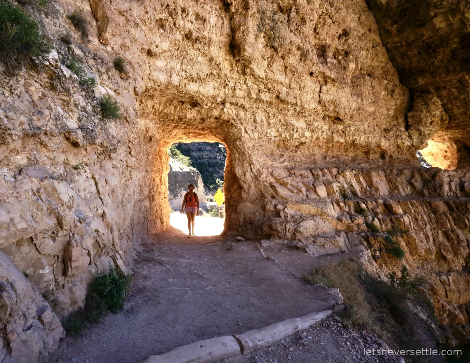Inga walking through a rock tunnel carved into the cliff on the Bright Angel Trail
