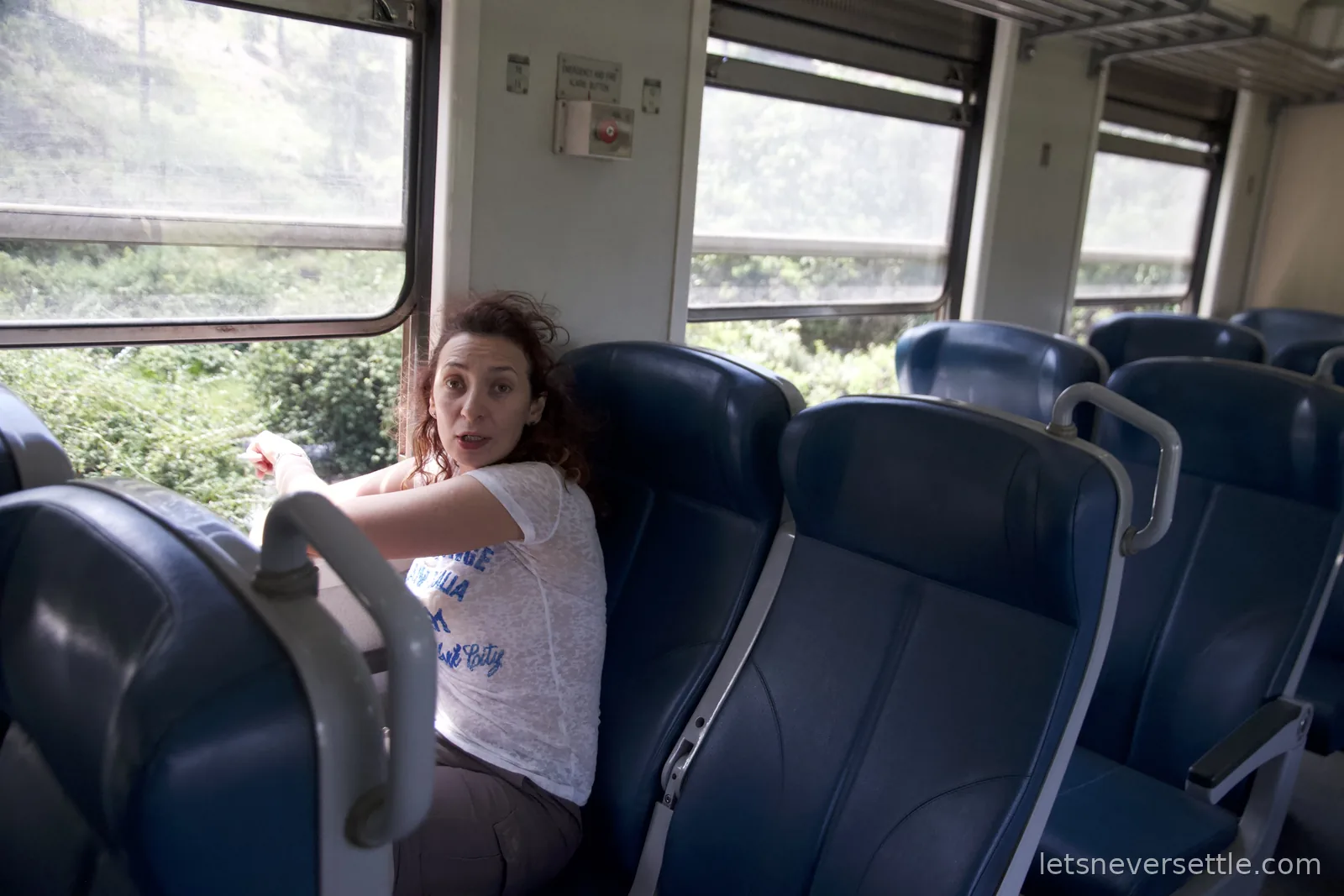 Inga turning around in her seat in an almost empty blue train carriage