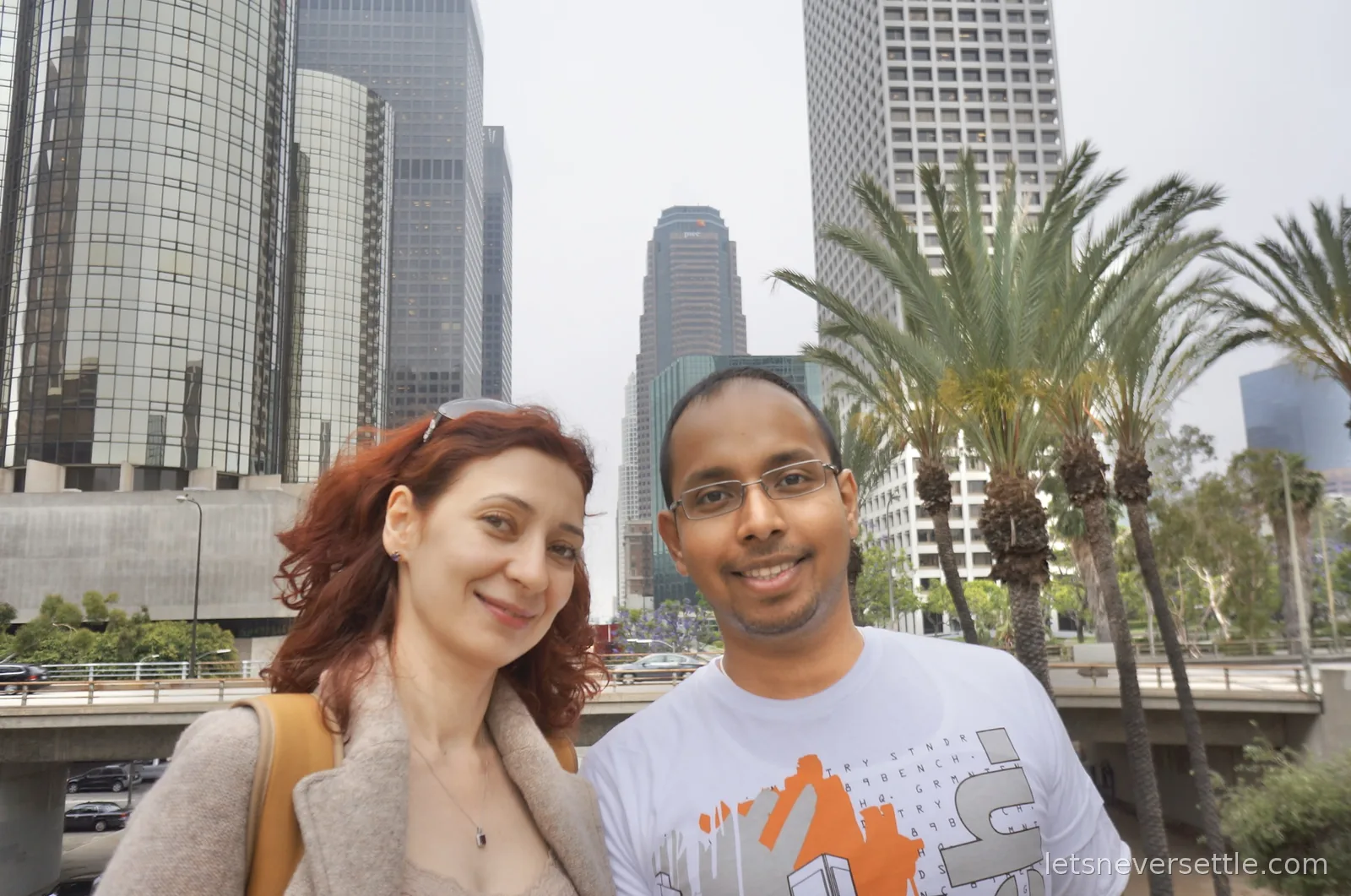 Selfie of Inga and Dileep among downtown Los Angeles towers including the cylindrical glass Westin Bonaventure