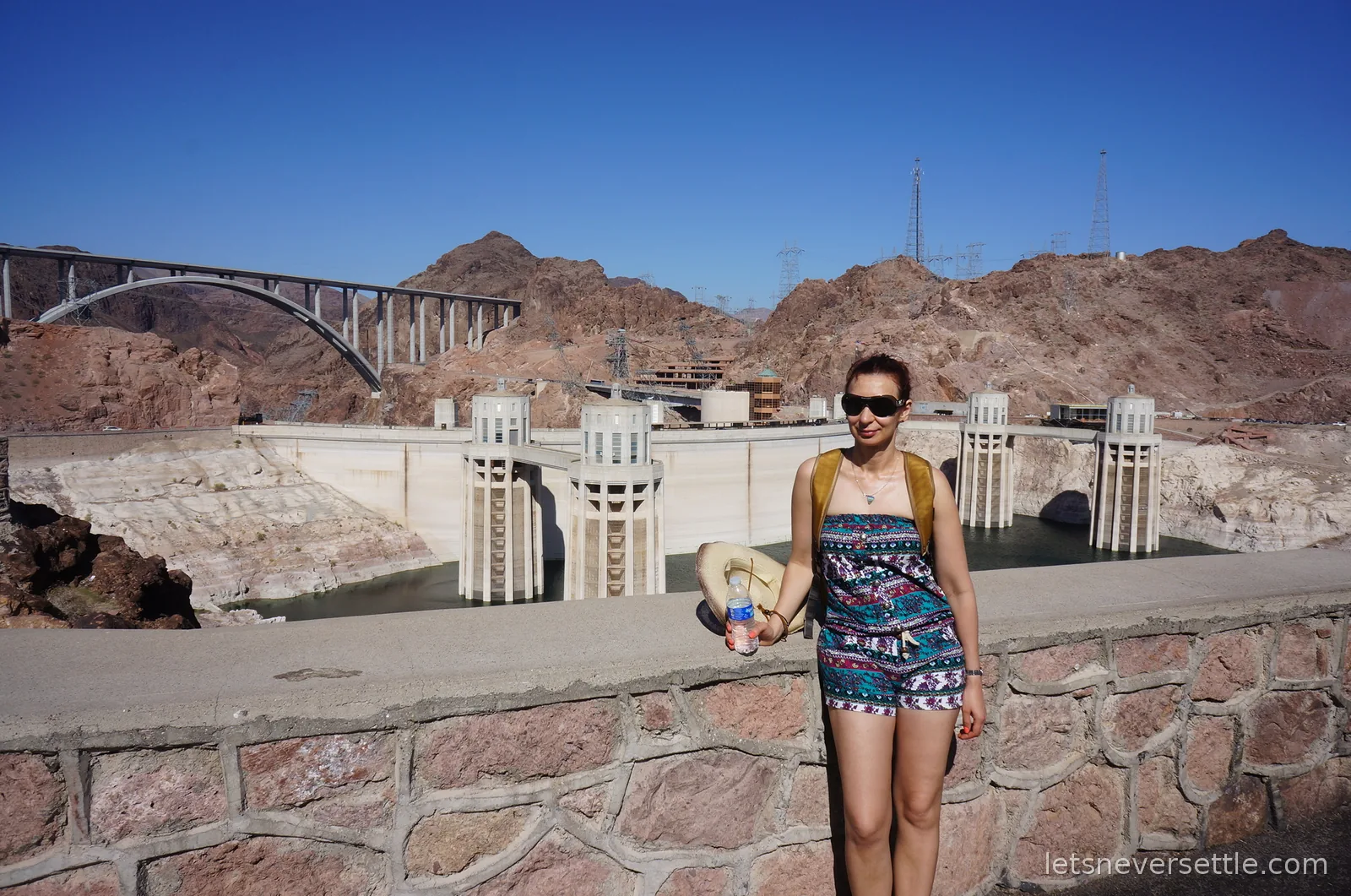 Inga in sunglasses at a stone overlook wall high above Hoover Dam
