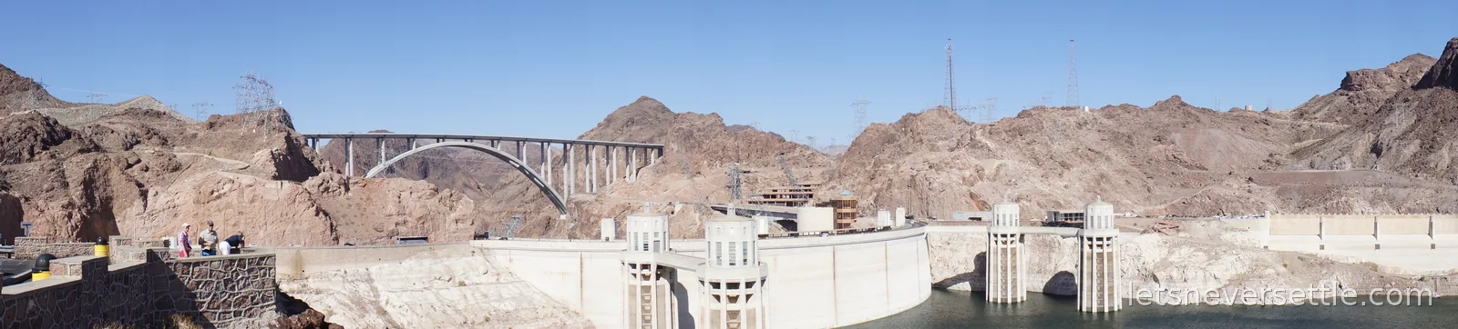 Panorama of Hoover Dam spanning the gorge with the bypass bridge arching over the Colorado River downstream