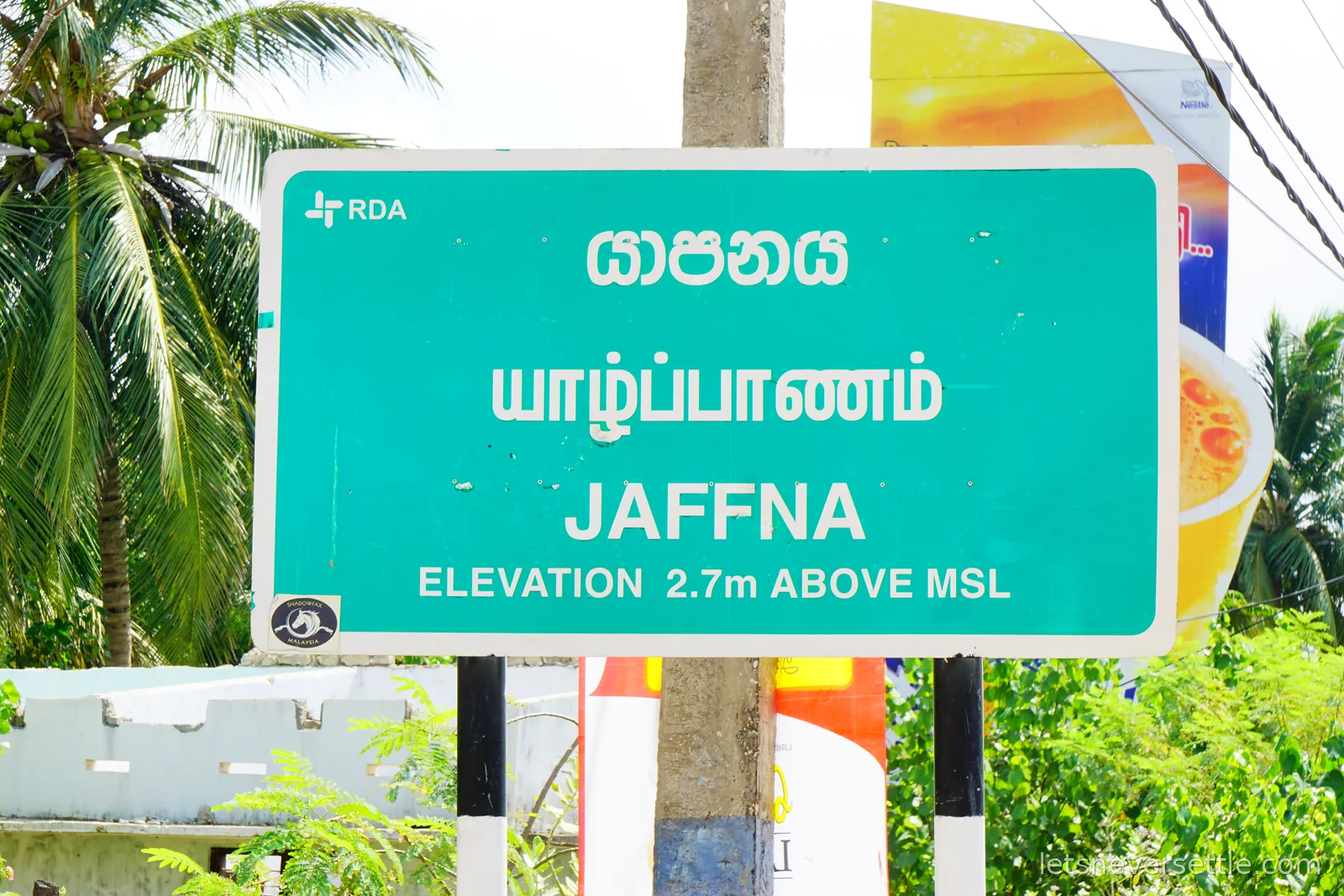 A green Sri Lankan road sign reading Jaffna in Sinhala, Tamil and English, with the line elevation 2.7m above MSL underneath