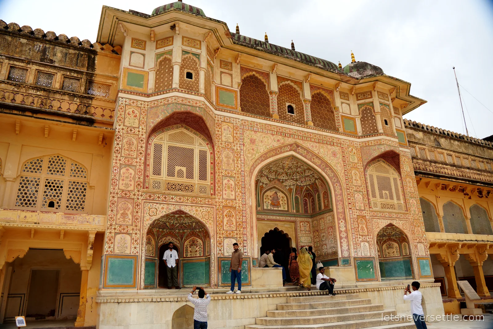 The Ganesh Pol gateway at Amber Fort, its facade covered in painted arches, floral frescoes and latticed marble balconies