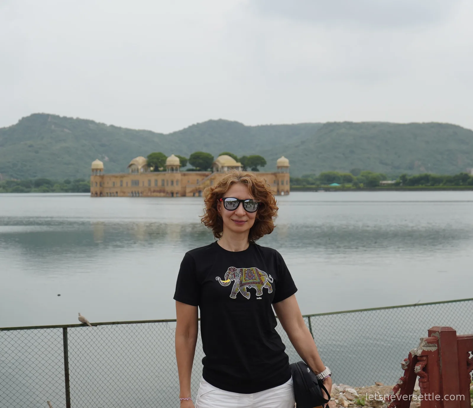Inga in a black elephant t-shirt in front of Jal Mahal, the sandstone palace sitting in the middle of Man Sagar Lake