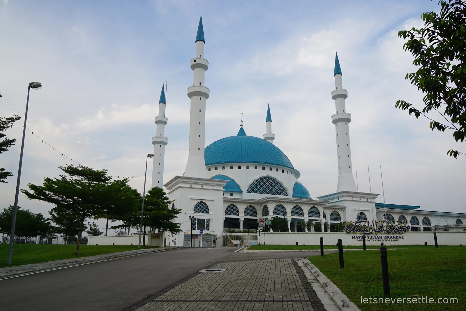 Masjid Sultan Iskandar in Bandar Baru Uda, Johor Bahru: a white mosque with a turquoise dome and four slender minarets under a pale morning sky