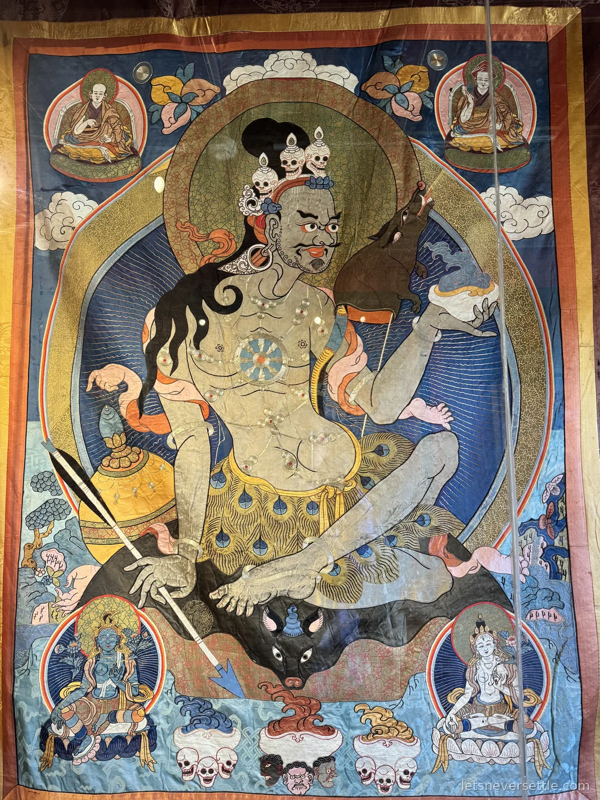 Large embroidered silk thangka of a wrathful protector deity, displayed behind glass at Erdene Zuu Monastery in Kharkhorin