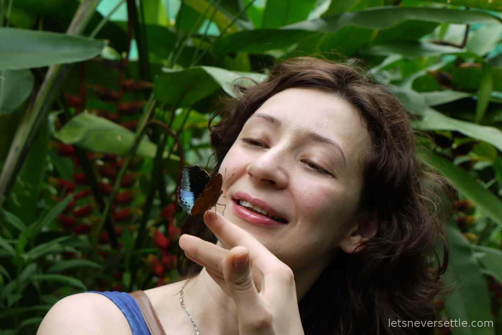 A butterfly perched on Inga's chin in the butterfly park