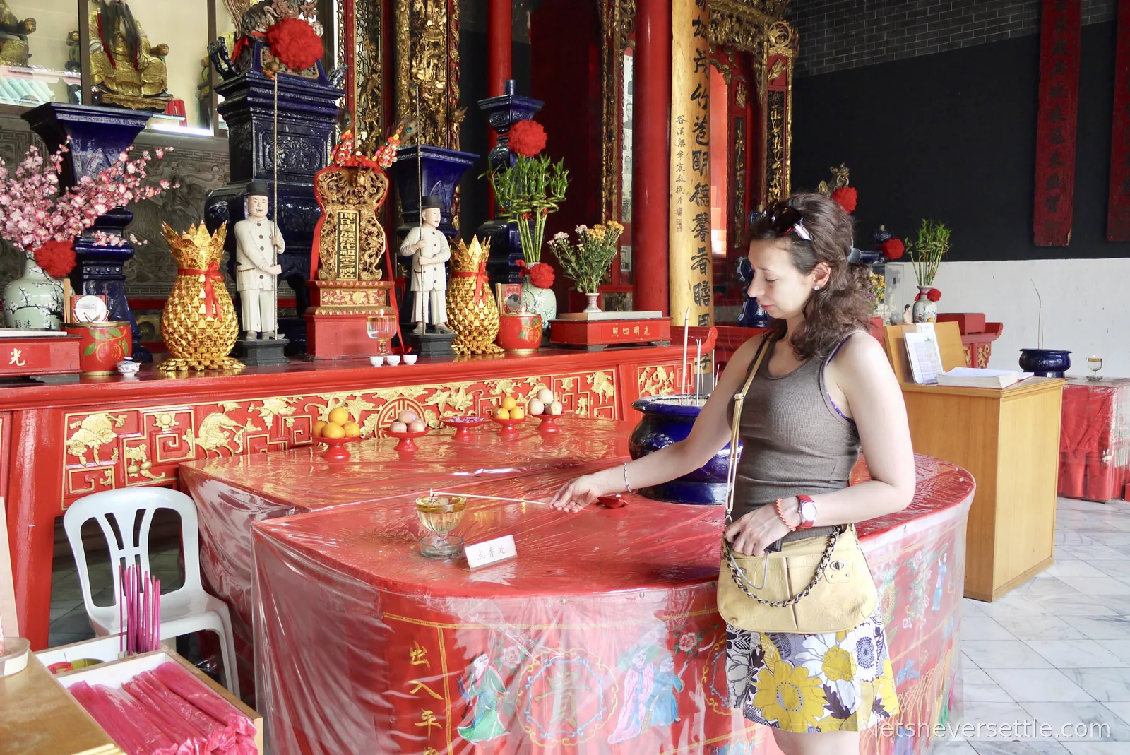 Inga lighting incense at the candle rack of a Chinese temple in Kuala Lumpur