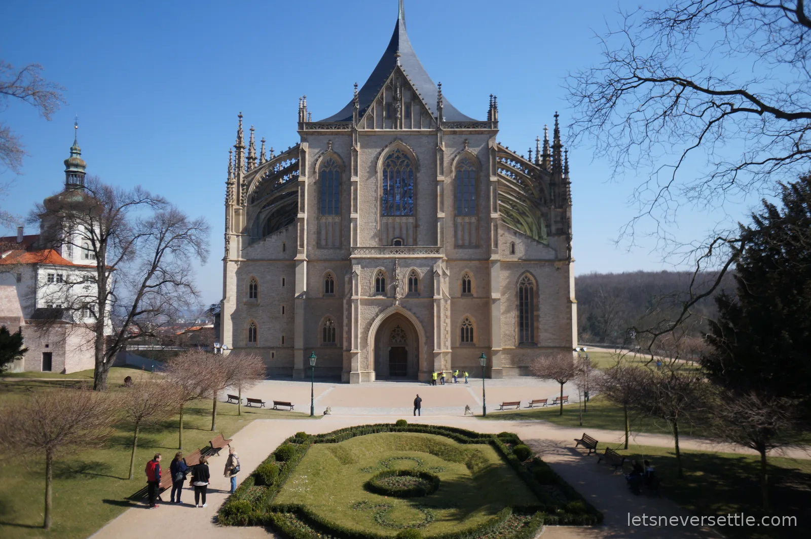 St Barbara's Cathedral in Kutna Hora seen across a formal garden, with flying buttresses, pinnacles and a steep tented roof