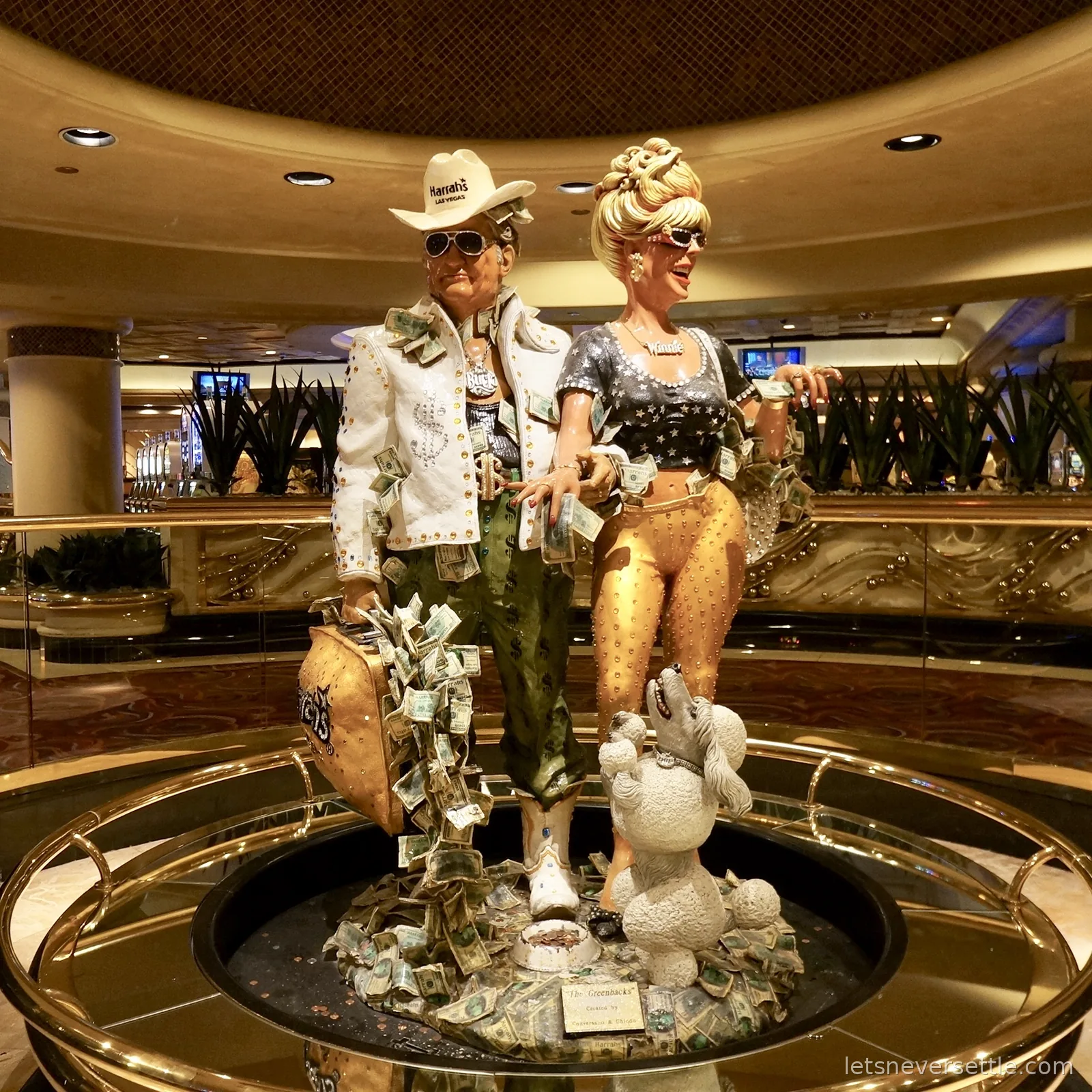 Two painted showgirl statues posing mid-kick in a casino lobby