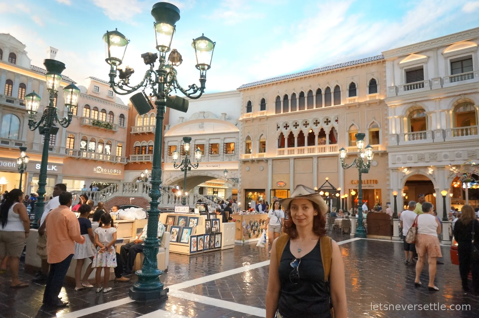 Inga in a straw hat in the Venetian's indoor St Mark's Square, Venetian facades and lamp posts under a painted evening sky