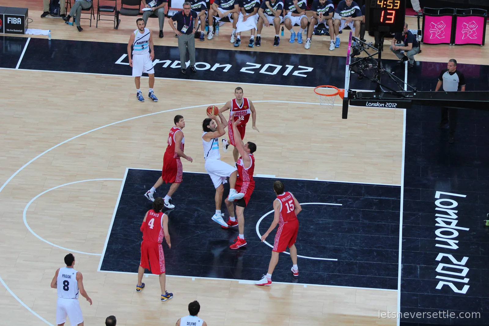Argentina in white and Russia in red contesting a shot under the basket at the London 2012 men's bronze medal basketball game