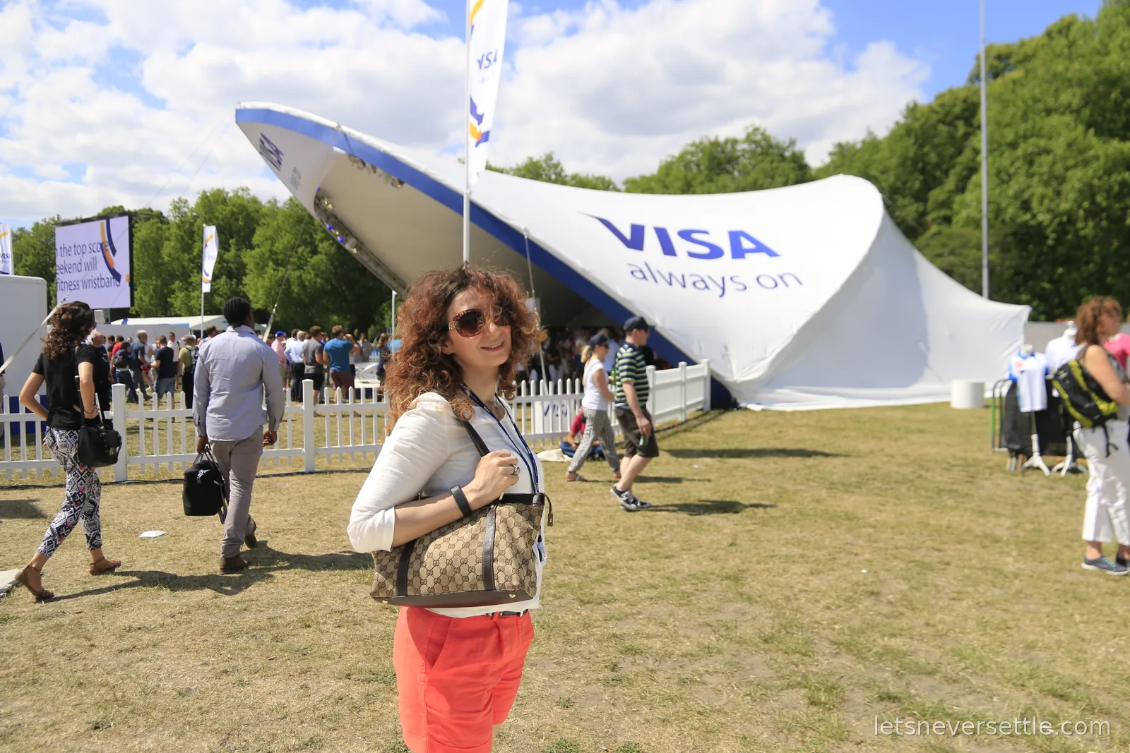 Inga standing on the grass in front of a large white sail-shaped Visa pavilion in the Formula E fan village