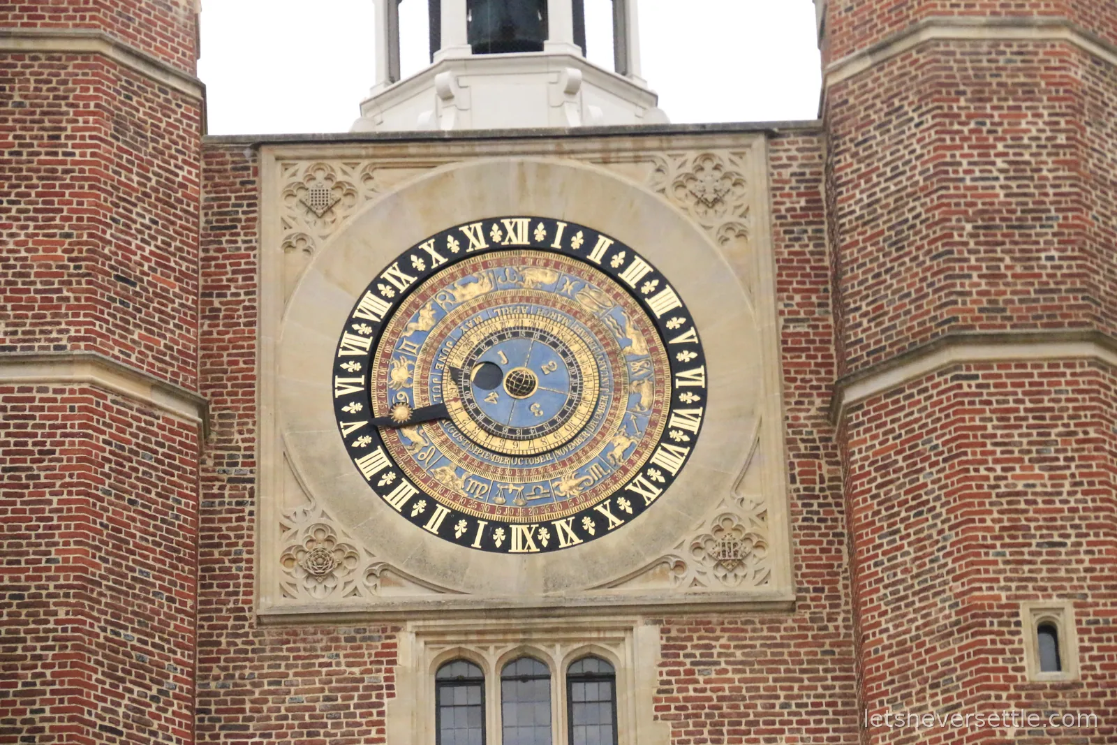 The blue and gold astronomical clock set into the red brick gatehouse tower at Hampton Court Palace