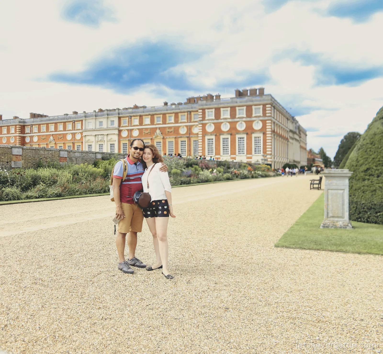 Inga and Dileep together on the gravel walk in front of the long garden front of Hampton Court Palace