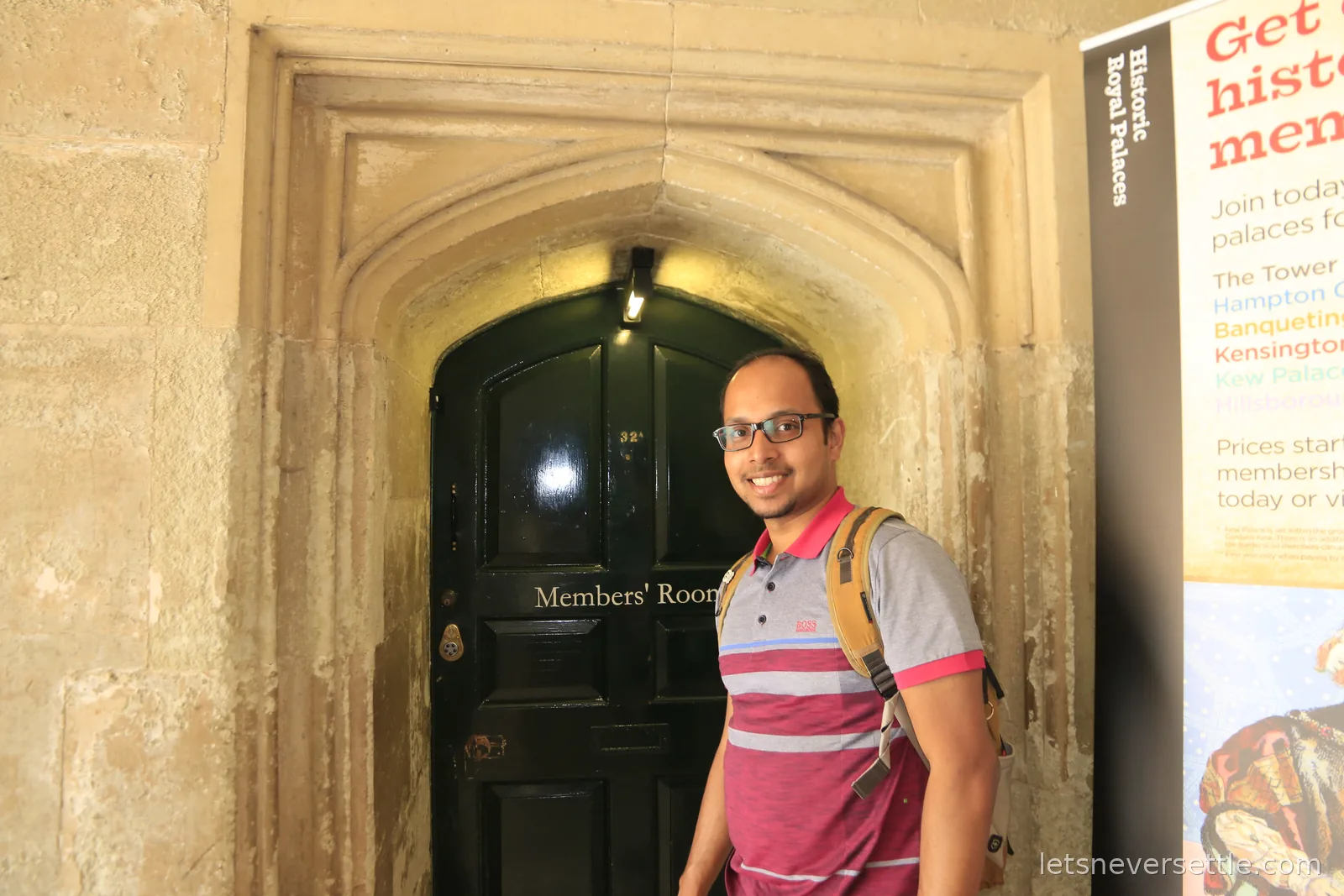 Dileep standing beside a dark green door lettered Members' Room in a stone Tudor archway at Hampton Court Palace, next to a Historic Royal Palaces membership banner