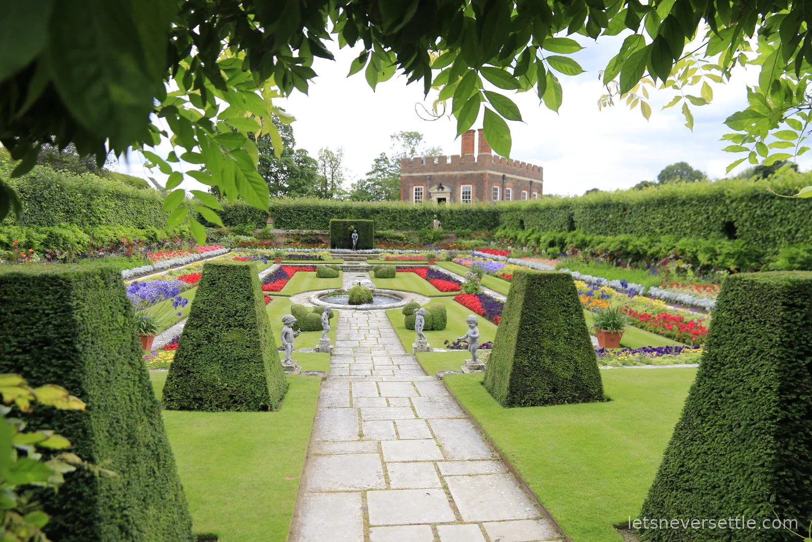 The sunken Pond Garden at Hampton Court Palace, tiered beds of white and red planting leading to a white garden building
