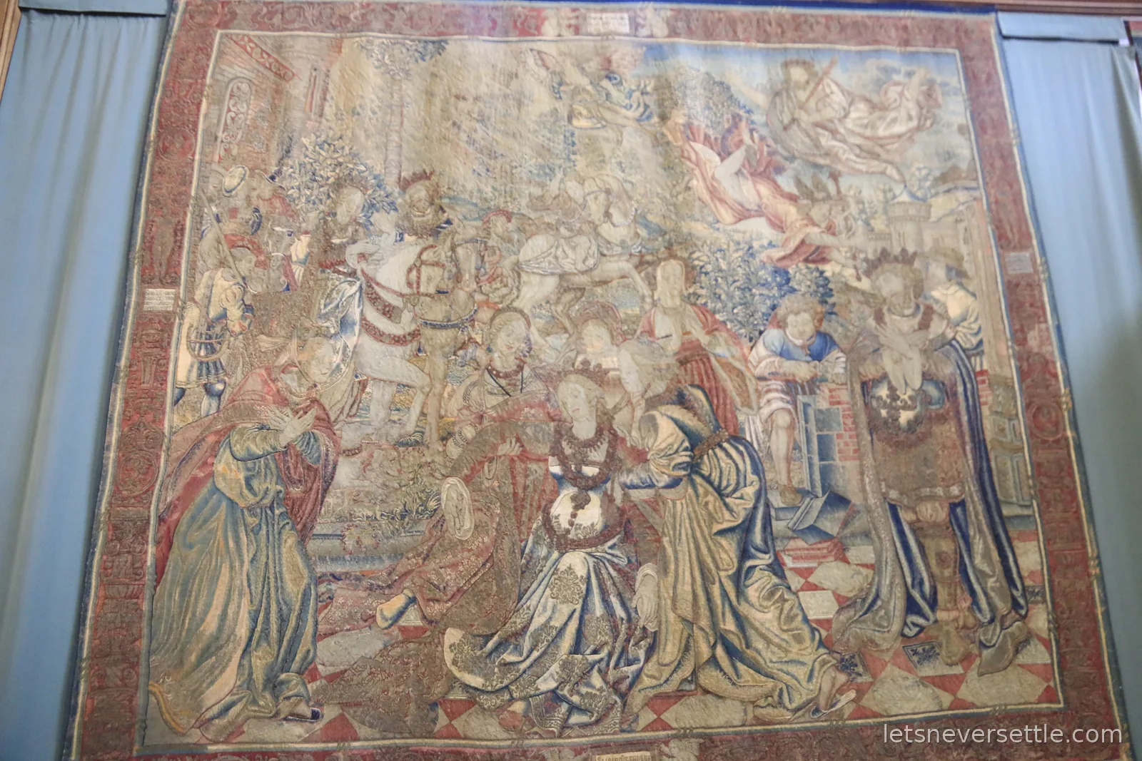 A vast historic tapestry hanging floor to ceiling in a state room at Hampton Court Palace
