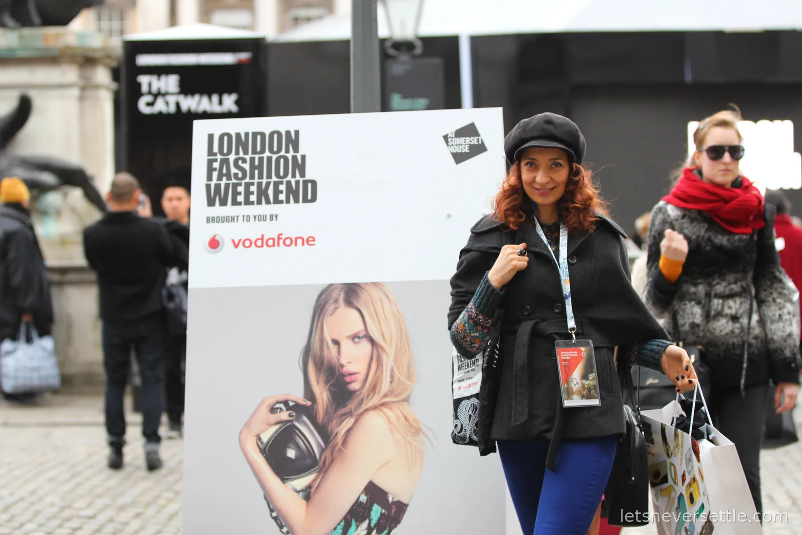 Inga in a black beret and lanyard beside a London Fashion Weekend board at Somerset House, The Catwalk sign in the background