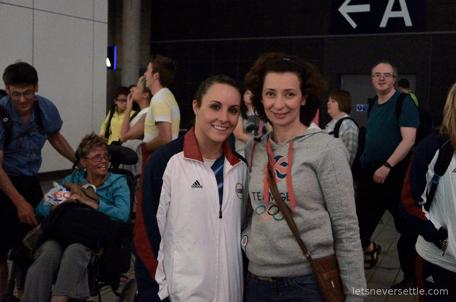 Inga in a Team GB hoodie standing arm in arm with American trampoline gymnast Savannah Vinsant in a white USA team jacket in the arena concourse