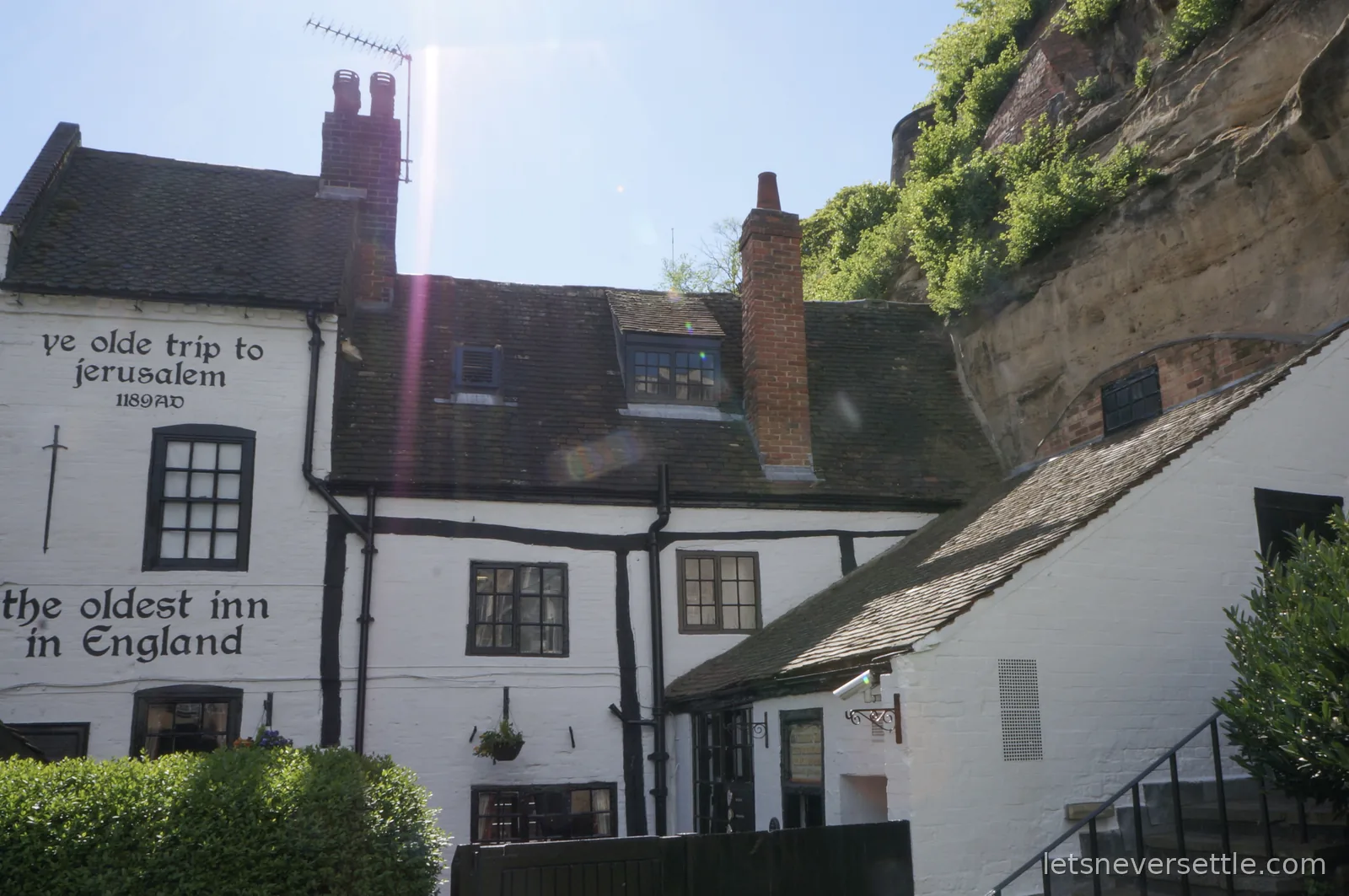 The white-painted Ye Olde Trip to Jerusalem pub built against the sandstone cliff below Nottingham Castle, its wall painted with 1189 AD and the oldest inn in England