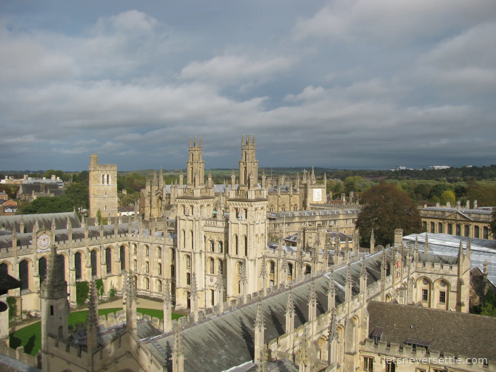 Rooftop view of the twin Gothic towers and quad of All Souls College in Oxford under a dramatic sky