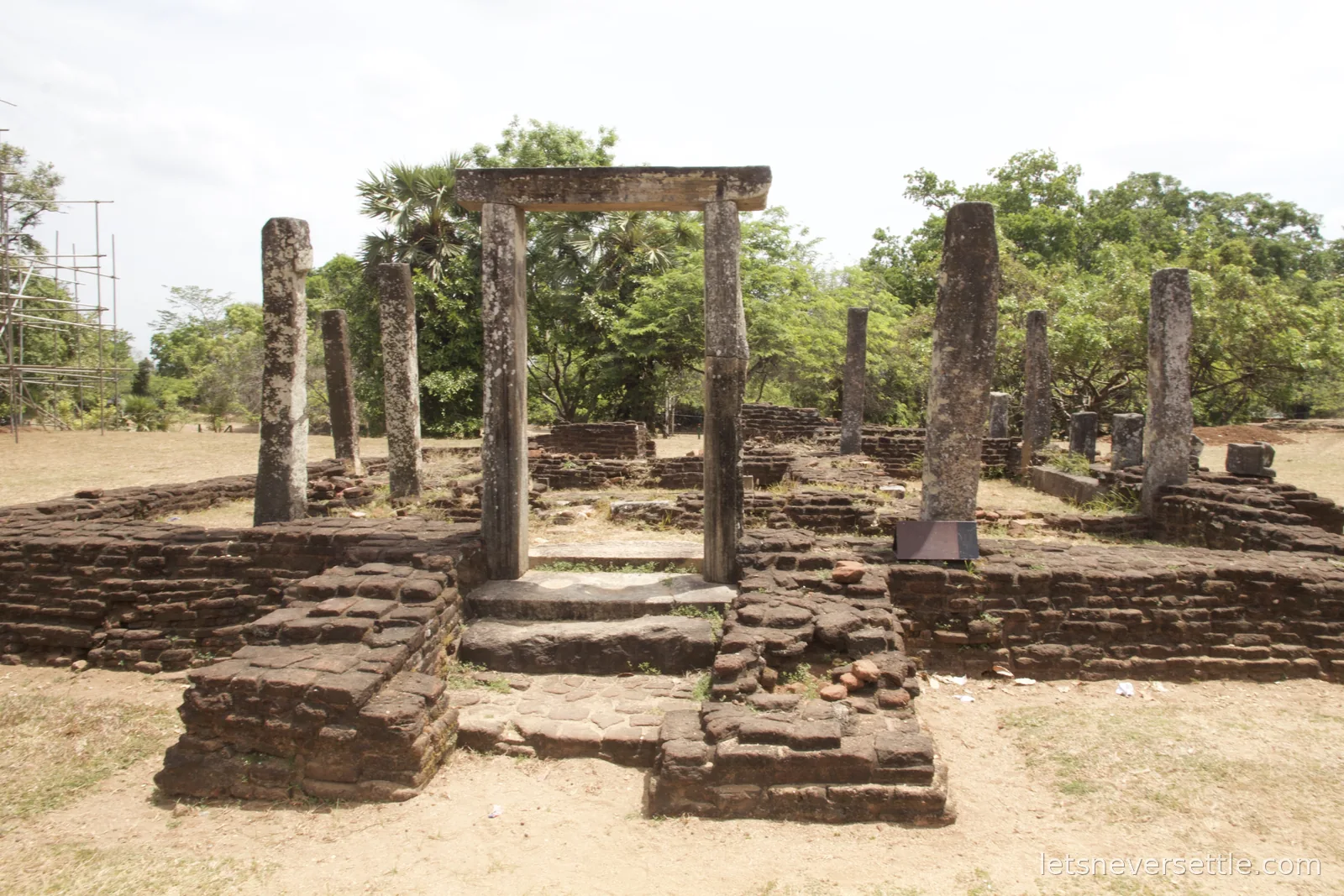 Inga standing at the stone lattice fence of the Nissanka Latha Mandapaya at Polonnaruwa, its pillars curved like lotus stalks