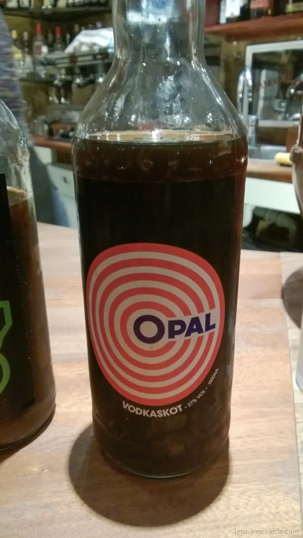 A bottle of Icelandic Opal vodkaskot liquorice shot on a wooden bar counter