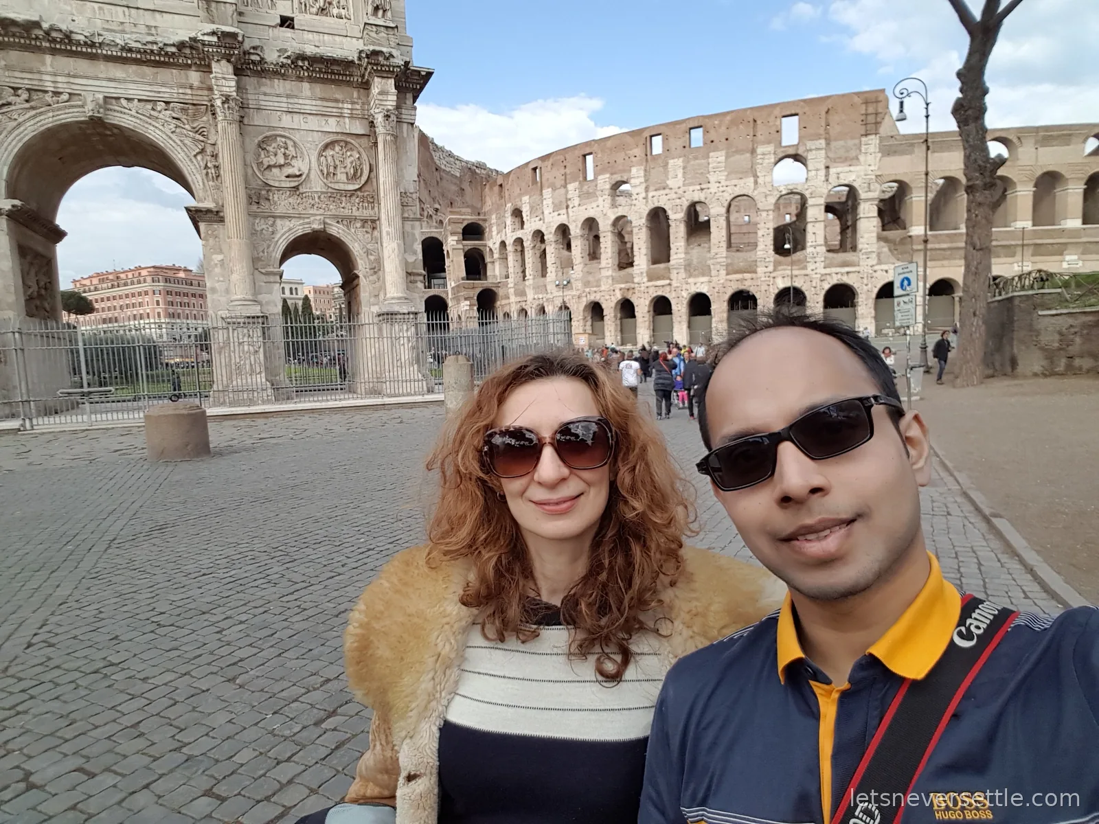 Inga and Dileep taking a selfie in sunglasses with the Arch of Constantine and the Colosseum behind them