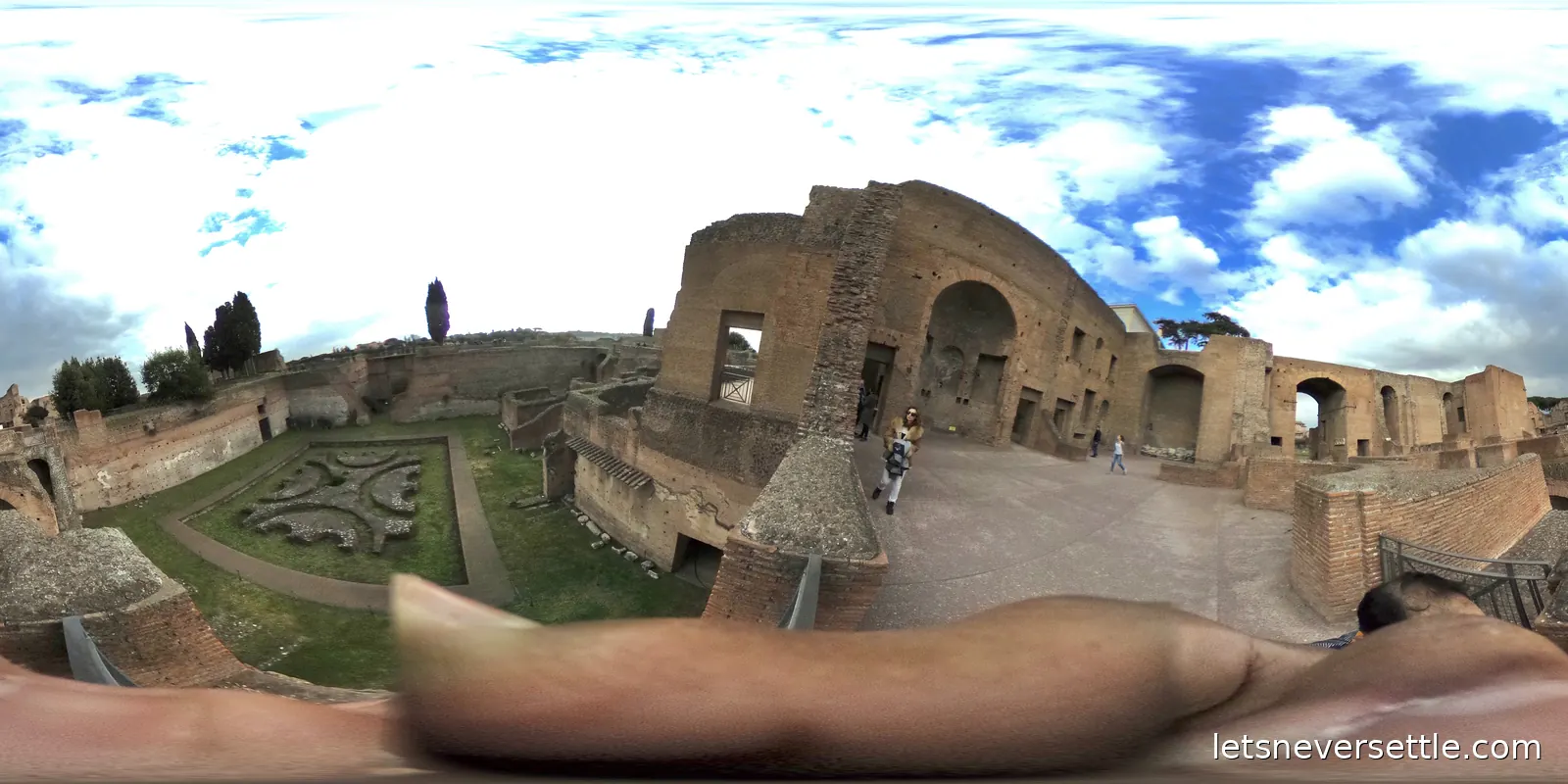 A sunken garden with clipped hedges laid out inside the brick walls of a ruined palace complex on the Palatine Hill