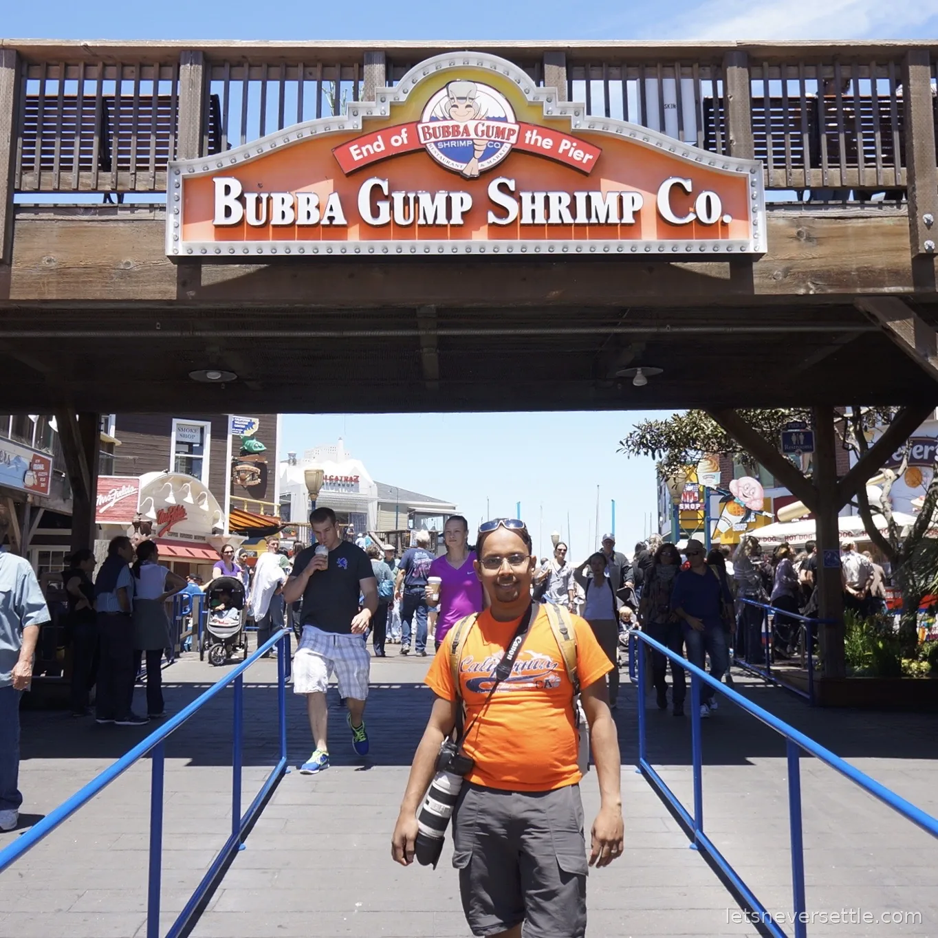 Dileep standing beneath the Bubba Gump Shrimp Co sign at the entrance to Pier 39