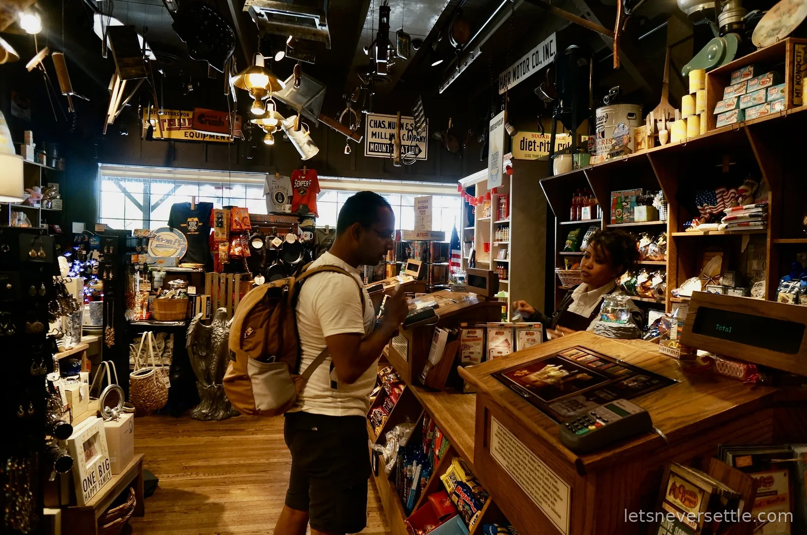 Dileep at the counter of a Cracker Barrel country store with shelves of goods behind him