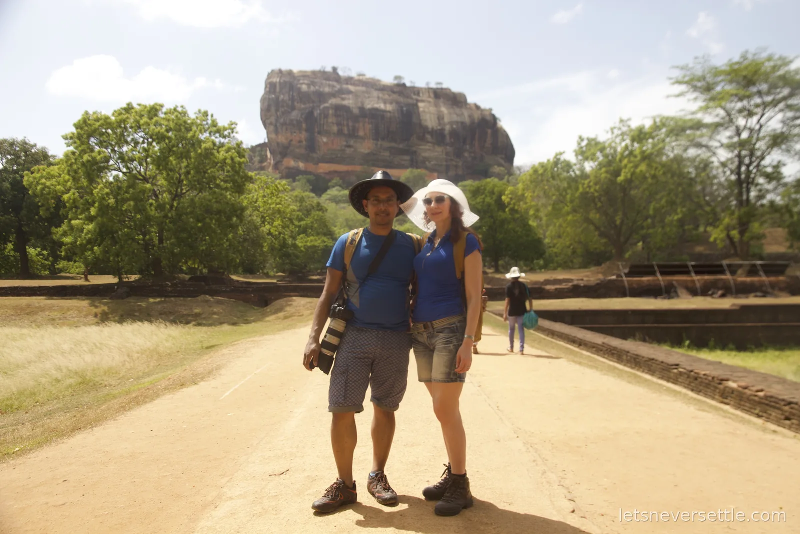 Dileep in a black sun hat and Inga in a white one on the long straight approach path to Sigiriya rock
