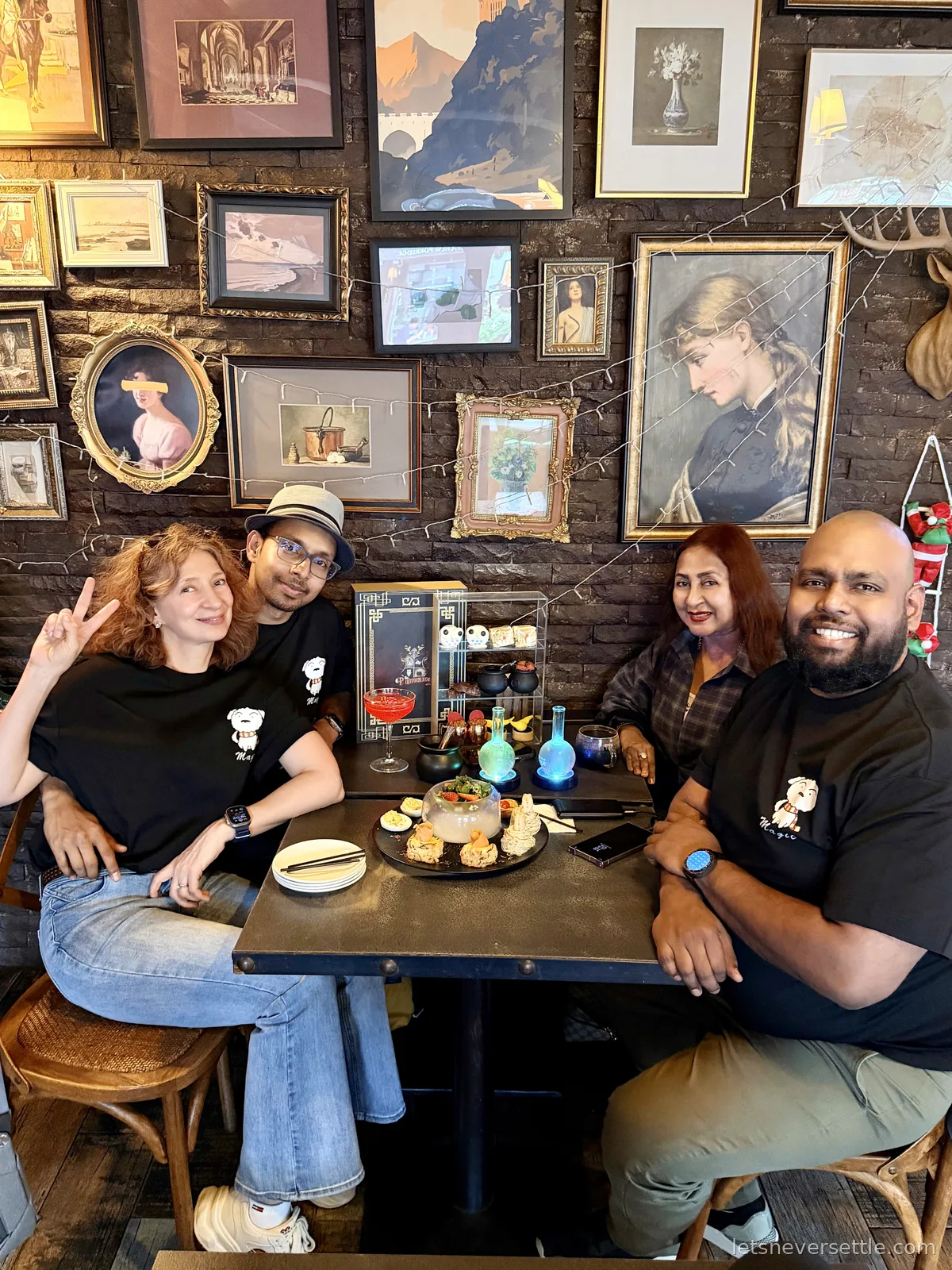 The family at a dark brick-walled cafe table with glowing potion bottles, tiny cauldrons and dry-ice smoke, framed portraits covering the wall