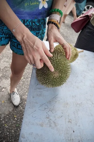 Several opened durians laid out together showing the different colours and textures of the varieties