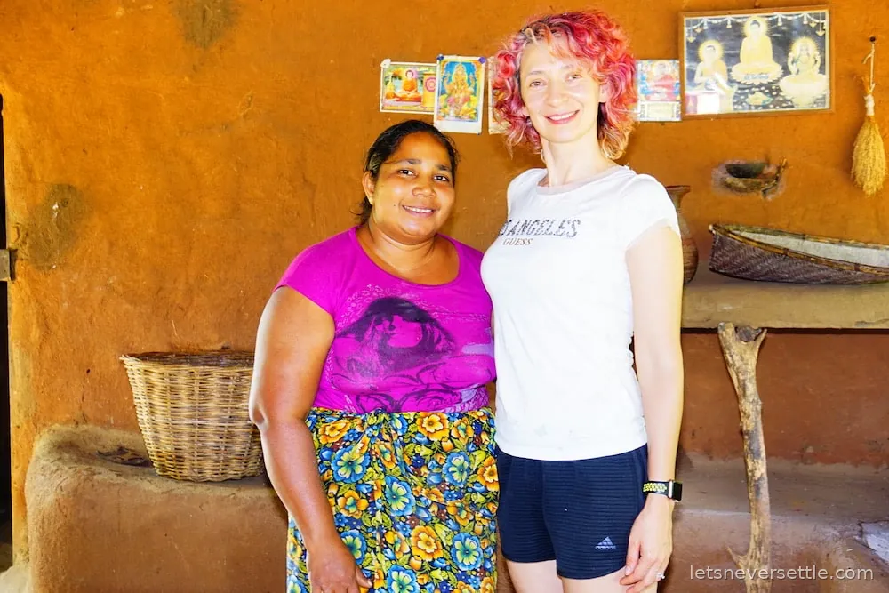 Inga standing with a Sri Lankan woman in a bright orange room, both smiling at the camera