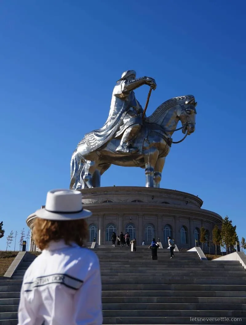Inga standing on the steps below the giant stainless steel equestrian statue of Chinggis Khaan in Mongolia