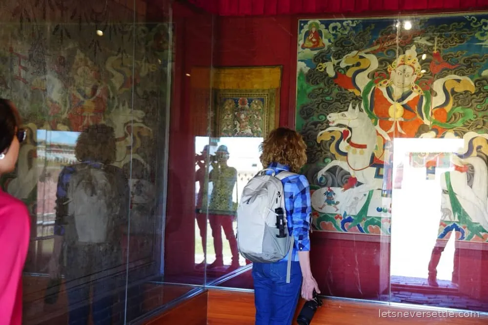 Inga looking at brightly painted Buddhist murals inside a temple at Erdene Zuu