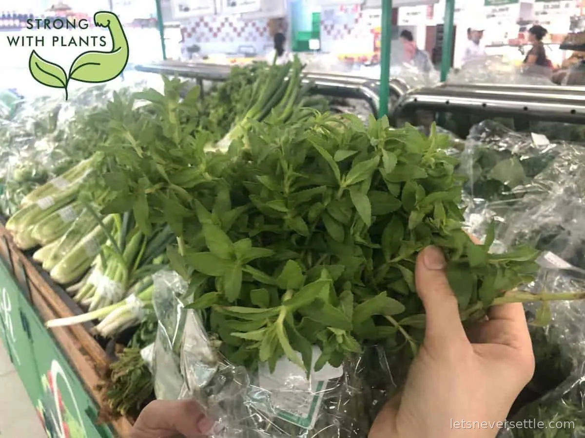 Bunches of fresh Vietnamese herbs bought at a market, laid out together on a table