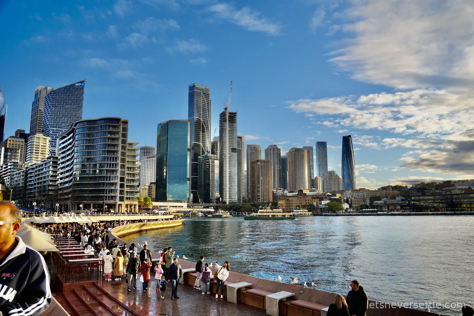 Sydney CBD skyline and Circular Quay waterfront with green and yellow ferries on the harbour
